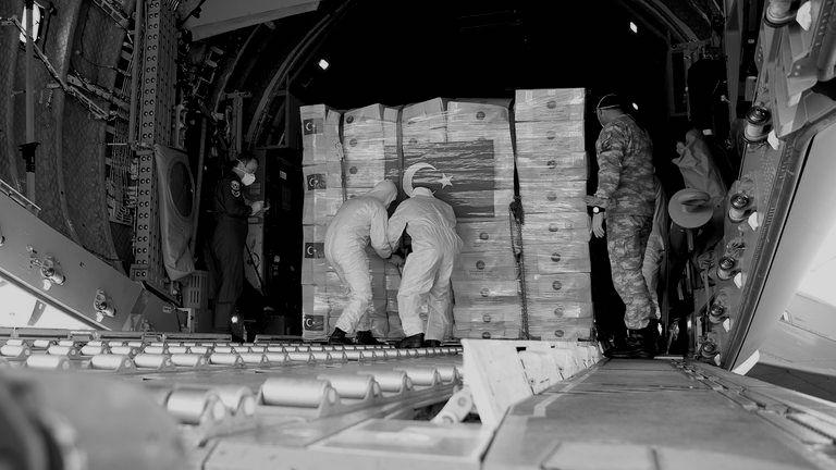 Soldiers loading PPE into the back of an aeroplane